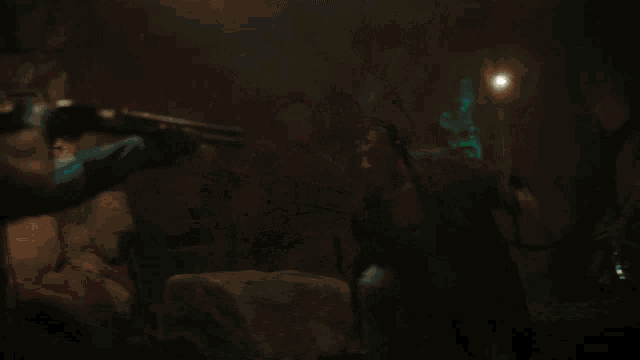 a man holding a gun in a dark room