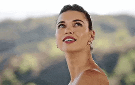 a woman is smiling and looking up at the sky .