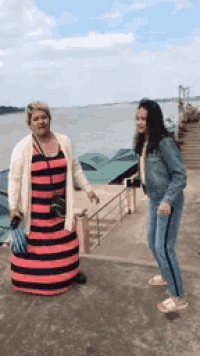 a woman in a striped dress is standing next to a woman in a denim jacket