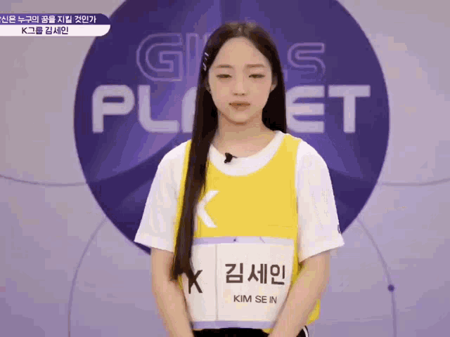 a girl with long hair stands in front of a sign that says girls planet