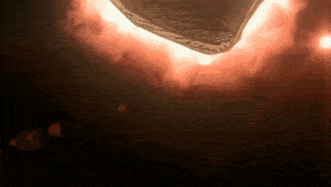 a fan is flying through the air in a dark room with red flames coming out of it .
