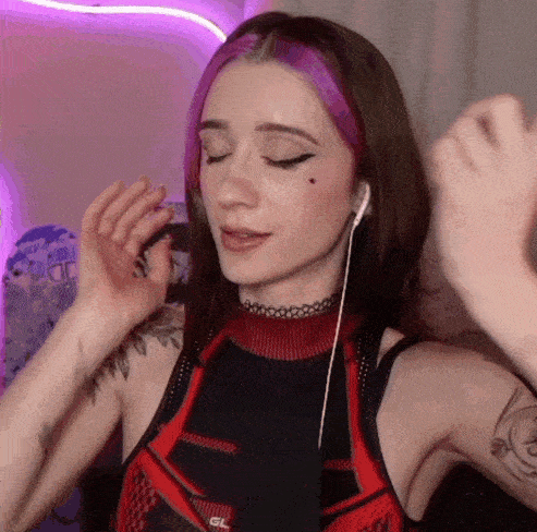 a girl with pink hair is wearing headphones and a choker