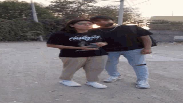 two people standing next to each other one wearing a t-shirt that says " nightmare "