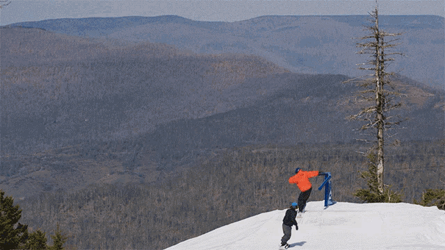 a snowboarder is doing a trick next to a snowshoe sign