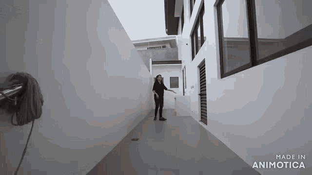 a woman is sweeping the floor in a hallway with a mop .