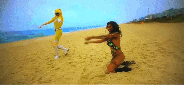 a man in a yellow superhero costume is running towards a woman in a bikini
