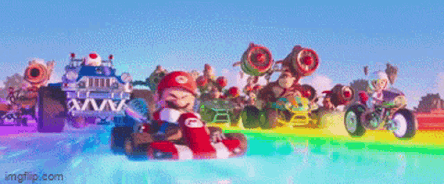 a group of mario kart racers are driving down a rainbow colored track .