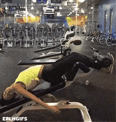 a woman in a yellow shirt is doing exercises on a machine in a gym