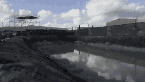 a large body of water surrounded by a fence and scaffolding