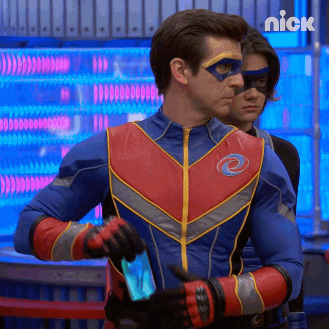 a man in a superhero costume is holding a cell phone next to another man in a nick advertisement