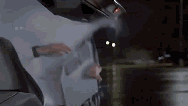 a person is opening the back door of a car .