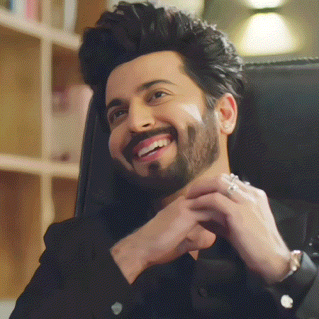 a man with a beard is sitting in a chair smiling .