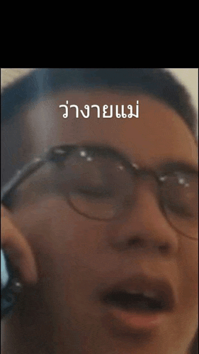 a man wearing glasses is making a funny face with his mouth open .