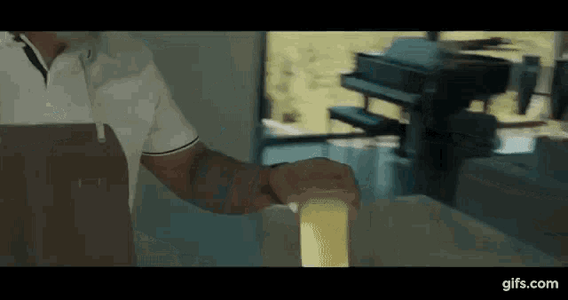 a man in a white shirt is standing in front of a printer .