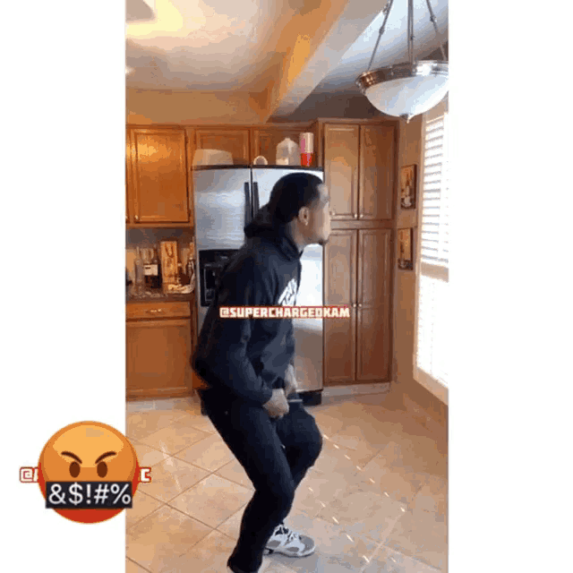 a man in a black hoodie is dancing in front of a refrigerator with the words superchargedkam on it