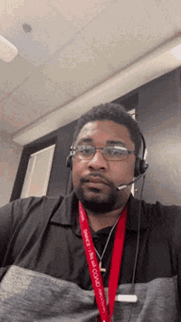 a man wearing headphones and a lanyard that says service is my goal