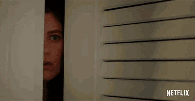 a woman peeking out of a door with a netflix logo on the bottom