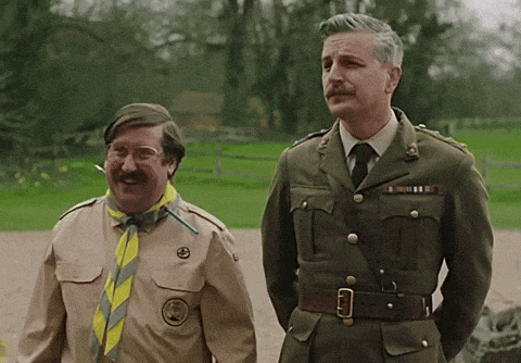a man in a military uniform stands next to another man in a scout uniform