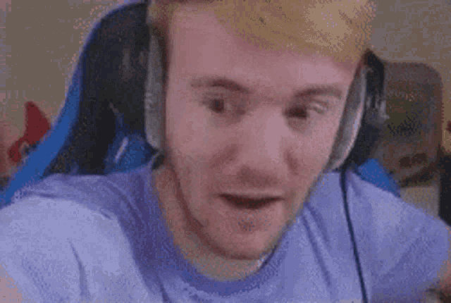 a close up of a man wearing headphones and making a surprised face