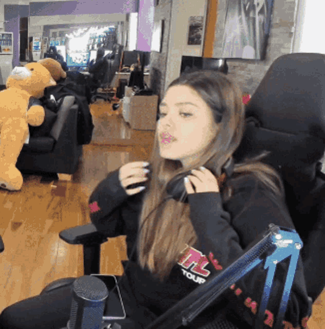 a woman sitting in a chair wearing a sweatshirt that says mtl tour on it