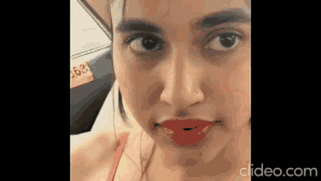 a close up of a woman 's face with red lips .