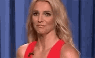 a woman in a red tank top is making a funny face .