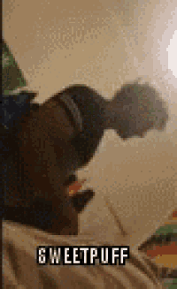 a person is laying on a bed taking a picture of themselves in a mirror with the words sweetpuff written on it .