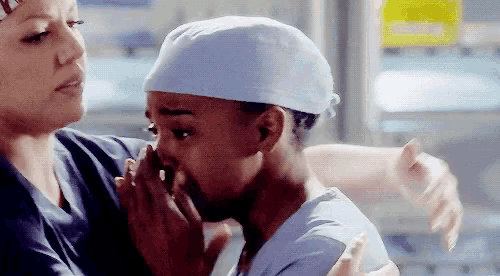 two nurses are hugging each other in a hospital room and one of them is crying .