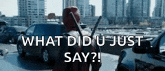 a man in a deadpool costume is standing in a parking lot holding a gun and asking what did u just say .