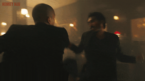 a poster for monkey man shows a couple fighting in a dark room