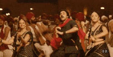 a man in a turban is dancing in front of a crowd of people