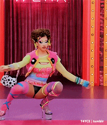 a woman in a colorful outfit is squatting down on a pink floor .