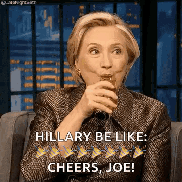 hillary clinton is sitting on a couch drinking a glass of wine and saying cheers joe .