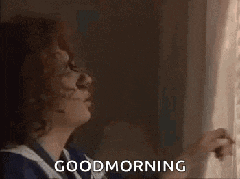 a woman is looking out of a window and says `` good morning '' .