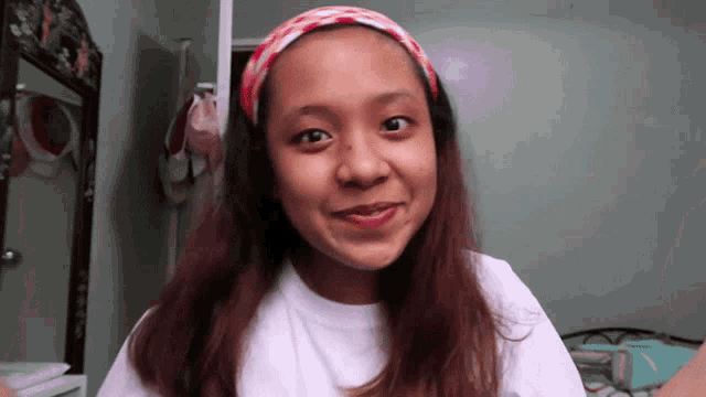 a girl wearing a headband looks at the camera