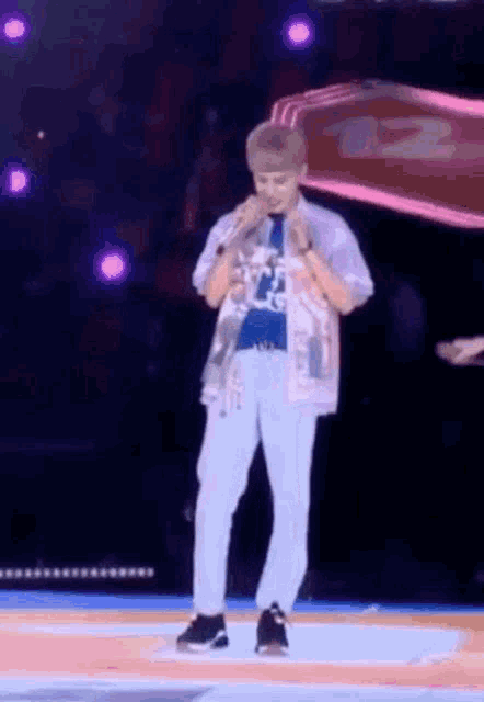 a man is standing on a stage with a microphone in his hand .