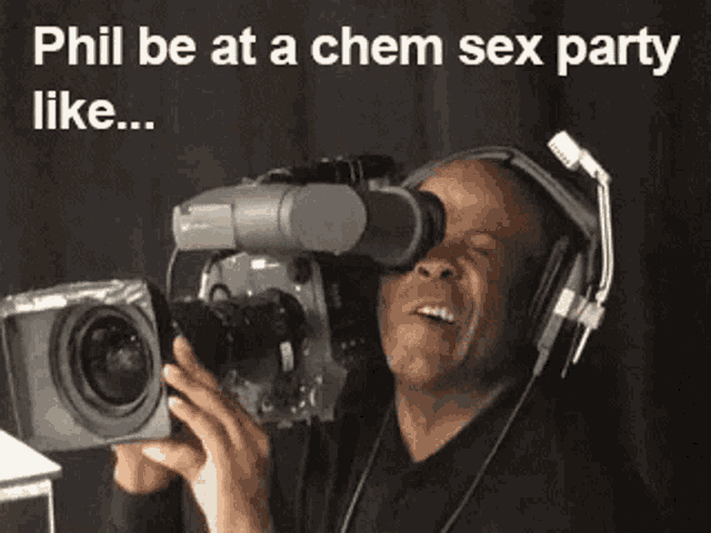 a man wearing headphones is holding a camera with the caption phil be at a chem sex party like ...
