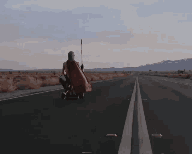 a man in a red cape is walking down an empty road