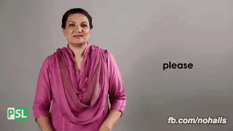 a woman in a pink shirt is making a sign language gesture .