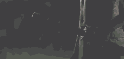 a man is holding a gun in his hand in a dark room .