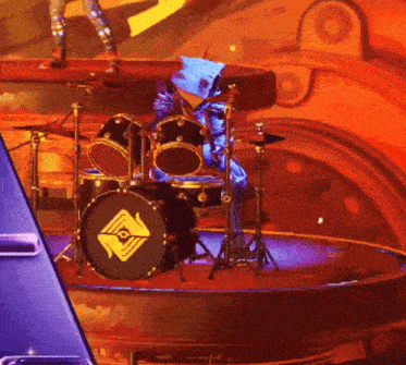 a person playing a drum set with a diamond on the drum head
