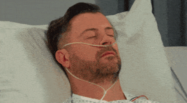 a man laying in a hospital bed with an oxygen mask on his nose