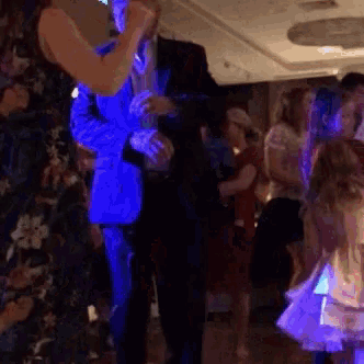 a man in a blue suit is dancing with a woman