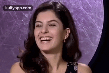 a close up of a woman laughing with her mouth open .