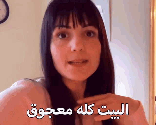 a woman in a pink shirt with arabic writing on her chest