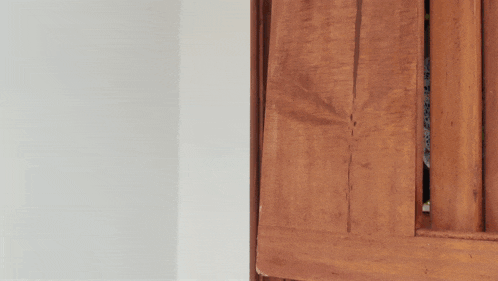 a wooden shelf with a white wall behind it