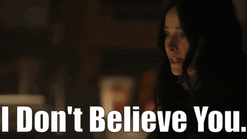 a woman in a dark room with the words " i don 't believe you " above her