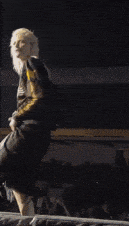 a woman with blonde hair is holding a microphone and wearing a shirt that says adidas on it