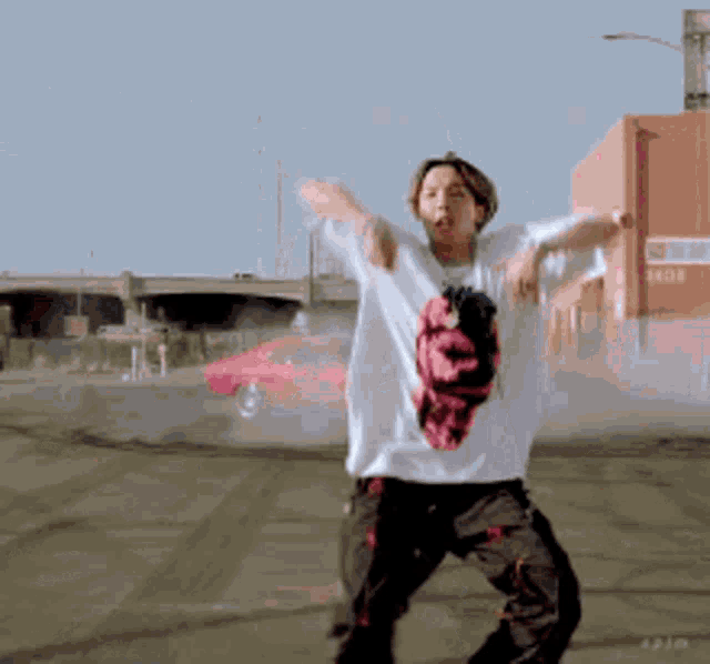 a man in a white shirt is dancing in front of a red building with the number 1808 on it
