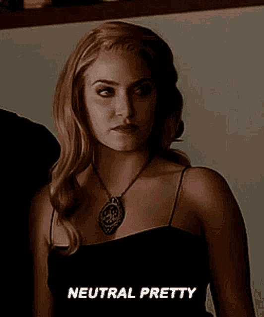 a woman is wearing a black dress and a necklace and says neutral pretty